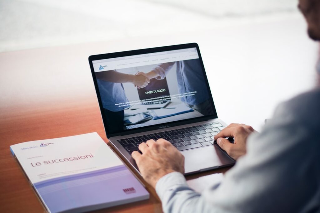 Mies näppäilee MacBook Prota, kädet lepäävät laitteen rannetuella.